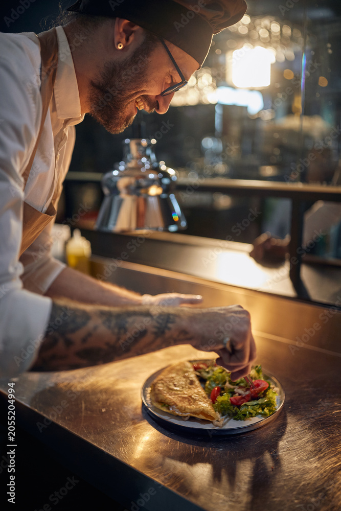 Chef finalizando um prato no passe da cozinha